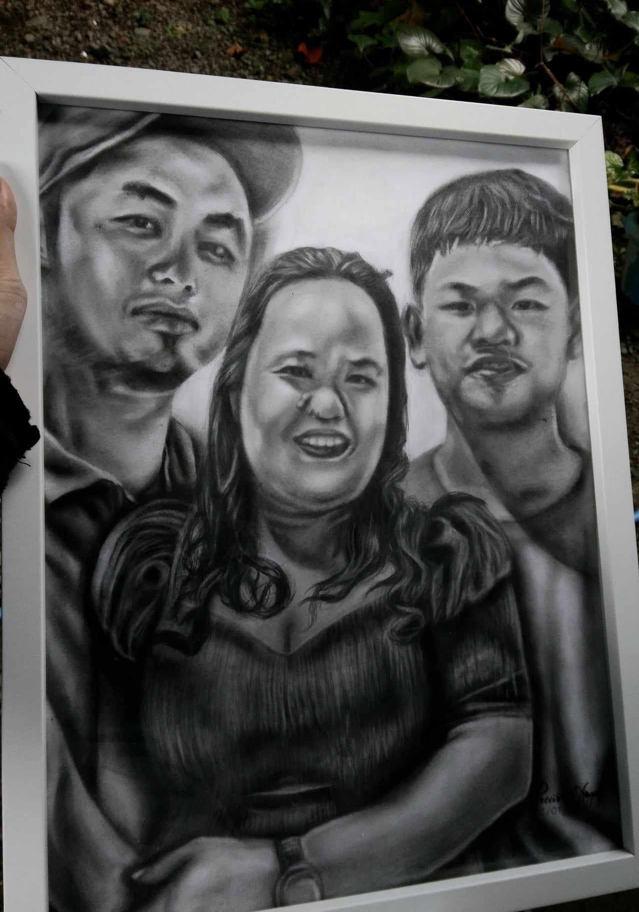 A framed graphite family portrait by Precious Angel Lopez